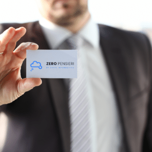 Uomo in abito che mostra un biglietto da visita bianco con logo cloud blu e scritta Zero Pensieri per immagine coordinata